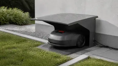 Robotgressklipper parkert ved ladestasjonen under en beskyttende garasje