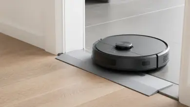 Robotstøvsuger kjører over en lav rampe i en døråpning